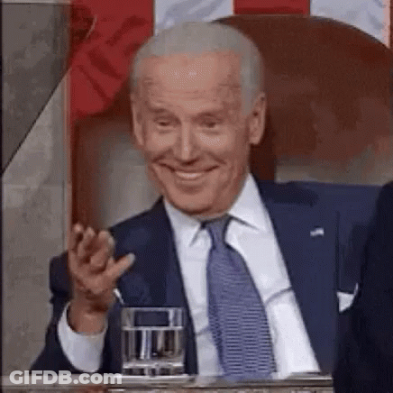 Man In Suit And Tie Smiling At Table GIF