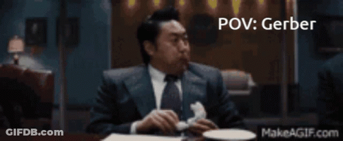 A Man In A Suit And Tie Is Sitting At A Table With A Makeagif.com Link In The Corner GIF