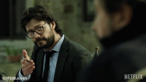 A Man In A Suit And Tie Is Sitting At A Table With A Netflix Logo On The Bottom GIF