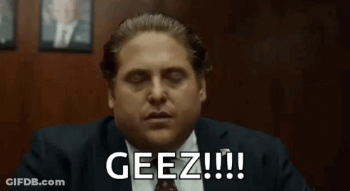 A Man In A Suit And Tie Is Sitting At A Table With His Eyes Closed And Says Geez !!! GIF