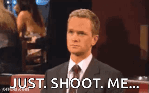 A Man In A Suit And Tie Is Sitting At A Table With His Hand On His Face . GIF