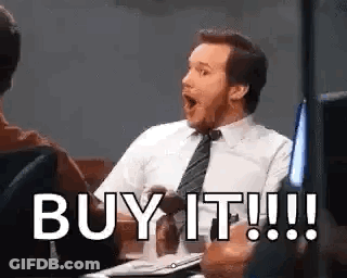 A Man In A Suit And Tie Is Sitting At A Table With His Mouth Open And Saying `` Buy It ! '' GIF