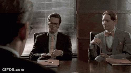 Man In Suit And Tie Sitting At Table GIF