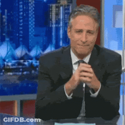 A Man In A Suit And Tie Is Sitting At A Table With The Words " I Wish " Written On It GIF