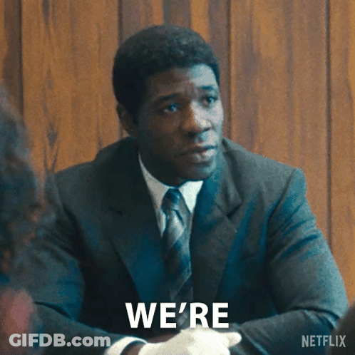 A Man In A Suit And Tie Is Sitting At A Table With The Words Investigating Written On The Bottom GIF