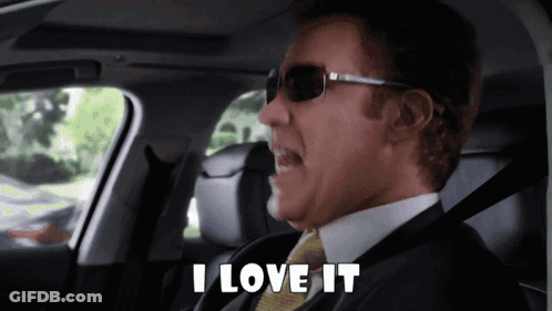A Man In A Suit And Tie Is Sitting In A Car And Says I Love It GIF