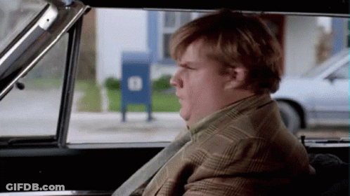 A Man In A Suit And Tie Is Sitting In A Car Looking Out The Window .. GIF