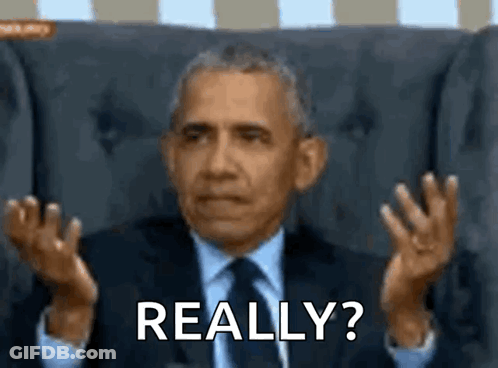 A Man In A Suit And Tie Is Sitting In A Chair And Making A Funny Face While Saying Really ? GIF