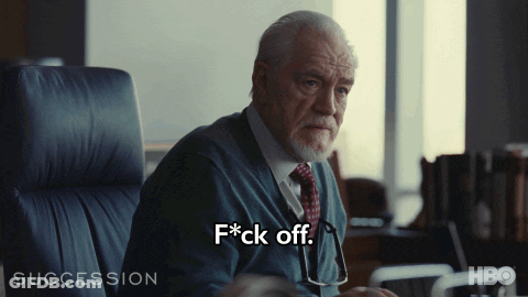 A Man In A Suit And Tie Is Sitting In A Chair And Saying F * Ck Off GIF