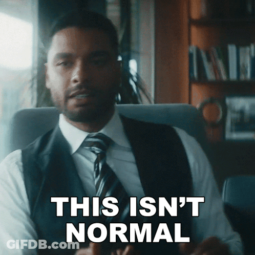 A Man In A Suit And Tie Is Sitting In A Chair And Says This Isn 'T Normal GIF