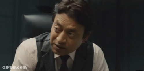 A Man In A Suit And Tie Is Sitting In A Chair And Talking To Someone . GIF