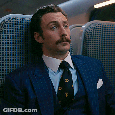 Man In Suit And Tie Sitting In Chair GIF