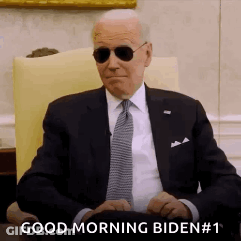 Man In Suit And Tie Wearing Sunglasses Saying Good Morning Biden GIF