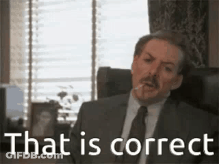 A Man In A Suit And Tie Is Sitting In A Chair With A Cigarette In His Mouth . GIF