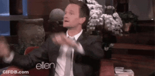 A Man In A Suit And Tie Is Sitting In A Chair With His Arms Outstretched On A Talk Show . GIF