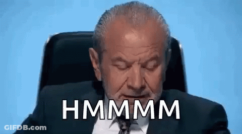 A Man In A Suit And Tie Is Sitting In A Chair With His Eyes Closed And The Words Hmmmm Written On His Face . GIF