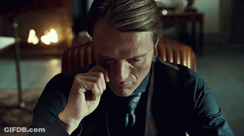 A Man In A Suit And Tie Is Sitting In A Chair With His Eyes Closed GIF