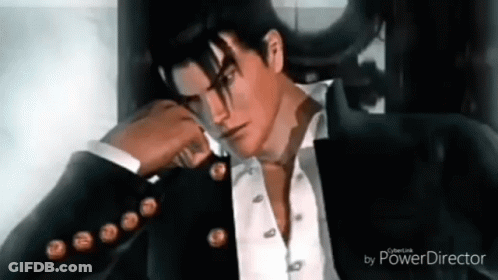 A Man In A Suit And Tie Is Sitting In A Chair With His Hand On His Face . GIF