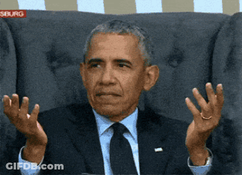 A Man In A Suit And Tie Is Sitting In A Chair With His Hands Outstretched In Front Of A Sign That Says Siburg GIF