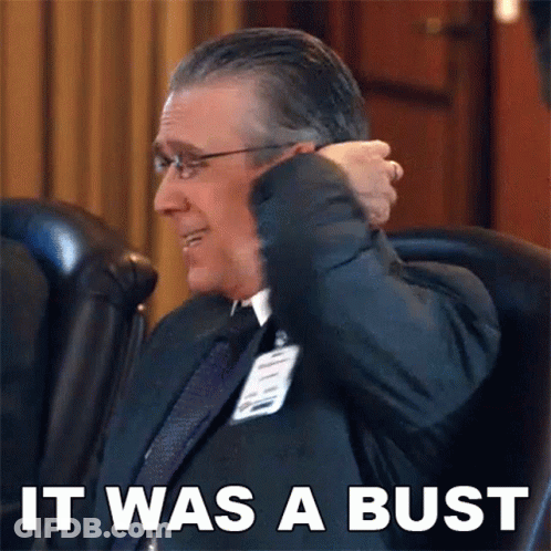 A Man In A Suit And Tie Is Sitting In A Chair With The Words " It Was A Bust " Above Him GIF