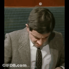 A Man In A Suit And Tie Is Sitting In A Chair With The Words Nosen Dahom Sna Written Below Him GIF