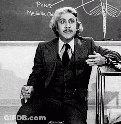 A Man In A Suit And Tie Is Sitting In Front Of A Chalkboard That Says Pong Medulla GIF