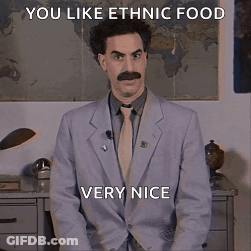 A Man In A Suit And Tie Is Sitting In Front Of A Map And Says You Like Ethnic Food Very Nice GIF
