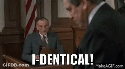 A Man In A Suit And Tie Is Sitting In Front Of A Microphone In A Courtroom . GIF