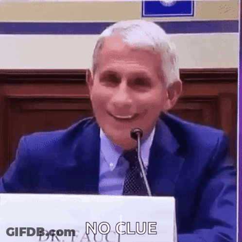 A Man In A Suit And Tie Is Sitting In Front Of A Microphone . GIF