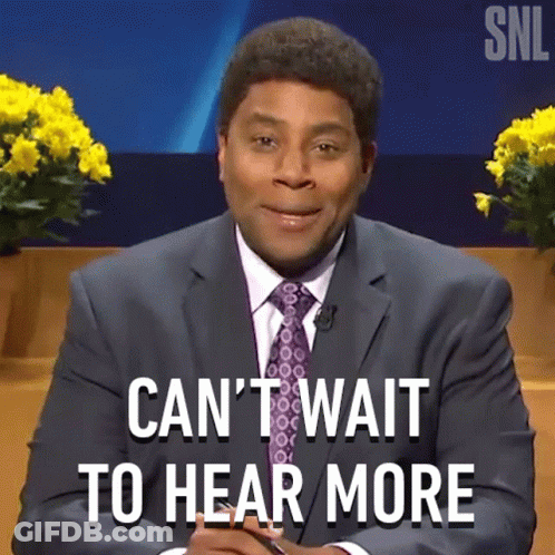 A Man In A Suit And Tie Is Sitting In Front Of A Sign That Says Can 'T Wait To Hear More GIF