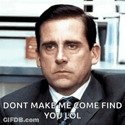 A Man In A Suit And Tie Is Sitting In Front Of A Sign That Says Dont Make Me Come Find You Lol GIF