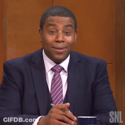 A Man In A Suit And Tie Is Sitting In Front Of A Snl Logo GIF