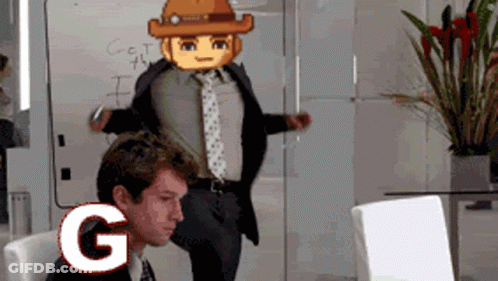A Man In A Suit And Tie Is Sitting In Front Of A White Board With The Letter G Written On It GIF