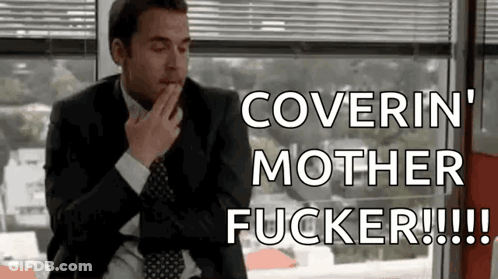 A Man In A Suit And Tie Is Sitting In Front Of A Window And Covering His Mouth . GIF