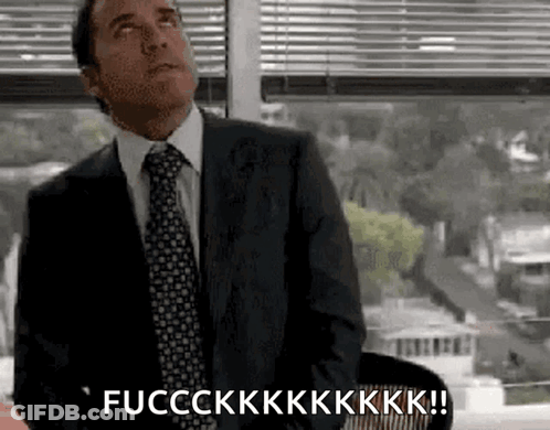 A Man In A Suit And Tie Is Sitting In Front Of A Window And Saying Fucckkk ! GIF