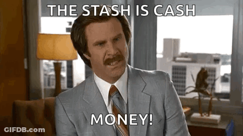 A Man In A Suit And Tie Is Sitting In Front Of A Window And Saying `` The Stash Is Cash Money '' . GIF