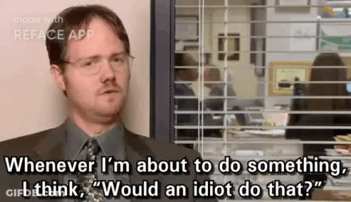 A Man In A Suit And Tie Is Sitting In Front Of A Window And Talking . GIF