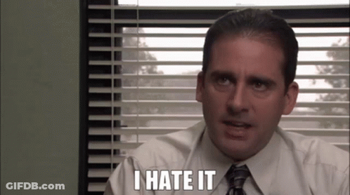 A Man In A Suit And Tie Is Sitting In Front Of A Window With Blinds And Says `` I Hate It '' . GIF
