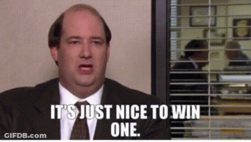 A Man In A Suit And Tie Is Sitting In Front Of A Window With Blinds And Says It 'S Just Nice To Win One GIF