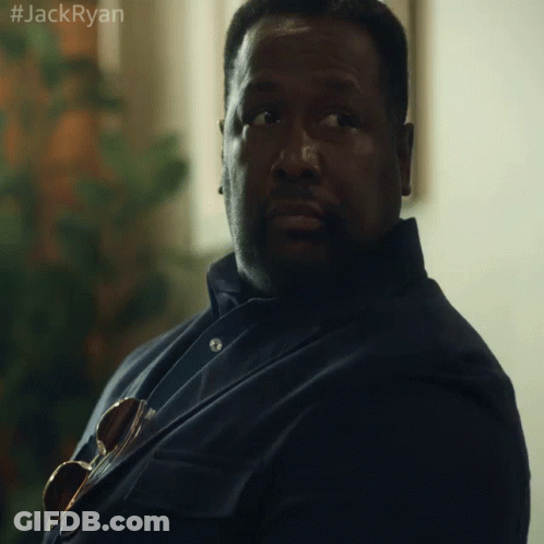 A Man In A Suit And Tie Is Sitting In Front Of A Window With The Hashtag #Jackryan On The Bottom Right GIF