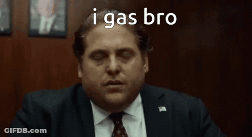 A Man In A Suit And Tie Is Sitting In Front Of A Wooden Wall With His Eyes Closed . GIF