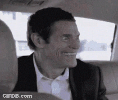 A Man In A Suit And Tie Is Sitting In The Back Seat Of A Car . GIF