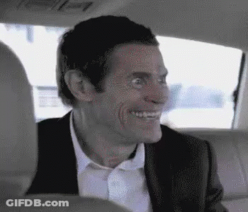 A Man In A Suit And Tie Is Sitting In The Back Seat Of A Car . GIF