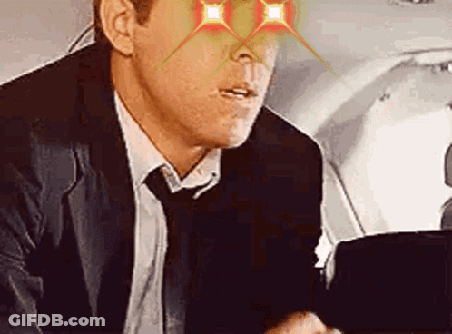 Man In Suit And Tie Sitting In Airplane GIF