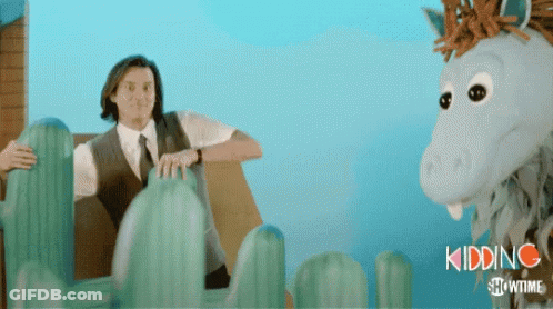 A Man In A Suit And Tie Is Sitting Next To A Stuffed Horse That Says Kidding Showtime On The Bottom GIF
