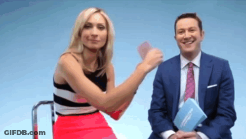 A Man In A Suit And Tie Is Sitting Next To A Woman In A Red Skirt GIF