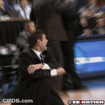 A Man In A Suit And Tie Is Sitting On A Basketball Court With A Sb Nation Logo On The Bottom GIF