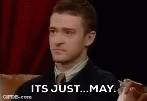 A Man In A Suit And Tie Is Sitting On A Couch And Saying `` It 'S Just May '' . GIF