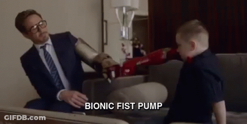A Man In A Suit And Tie Is Sitting On A Couch Talking To A Young Boy . GIF