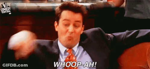 A Man In A Suit And Tie Is Sitting On A Couch With His Arms Outstretched And Saying Whoop-Ah . GIF